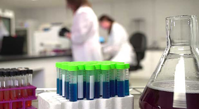 Lab viles and beaker with people in background 1